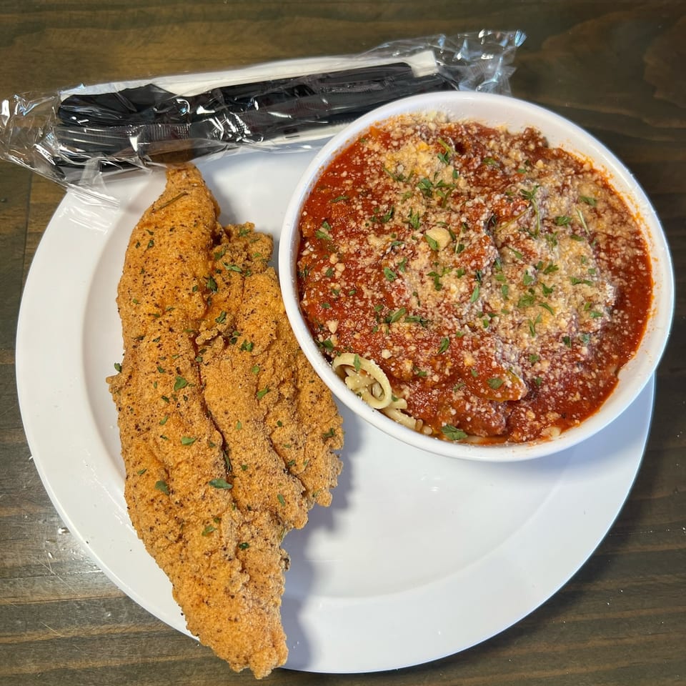 Fried fish fillets and a bowl of spaghetti with red sauce and parmesan cheese.